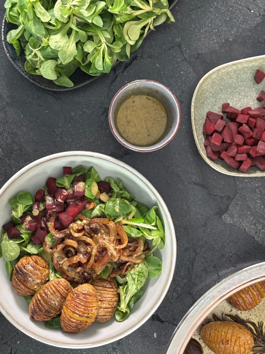 Hasselback-Kartoffel-Bowl mit Bier-Zwiebeln und Feldsalat